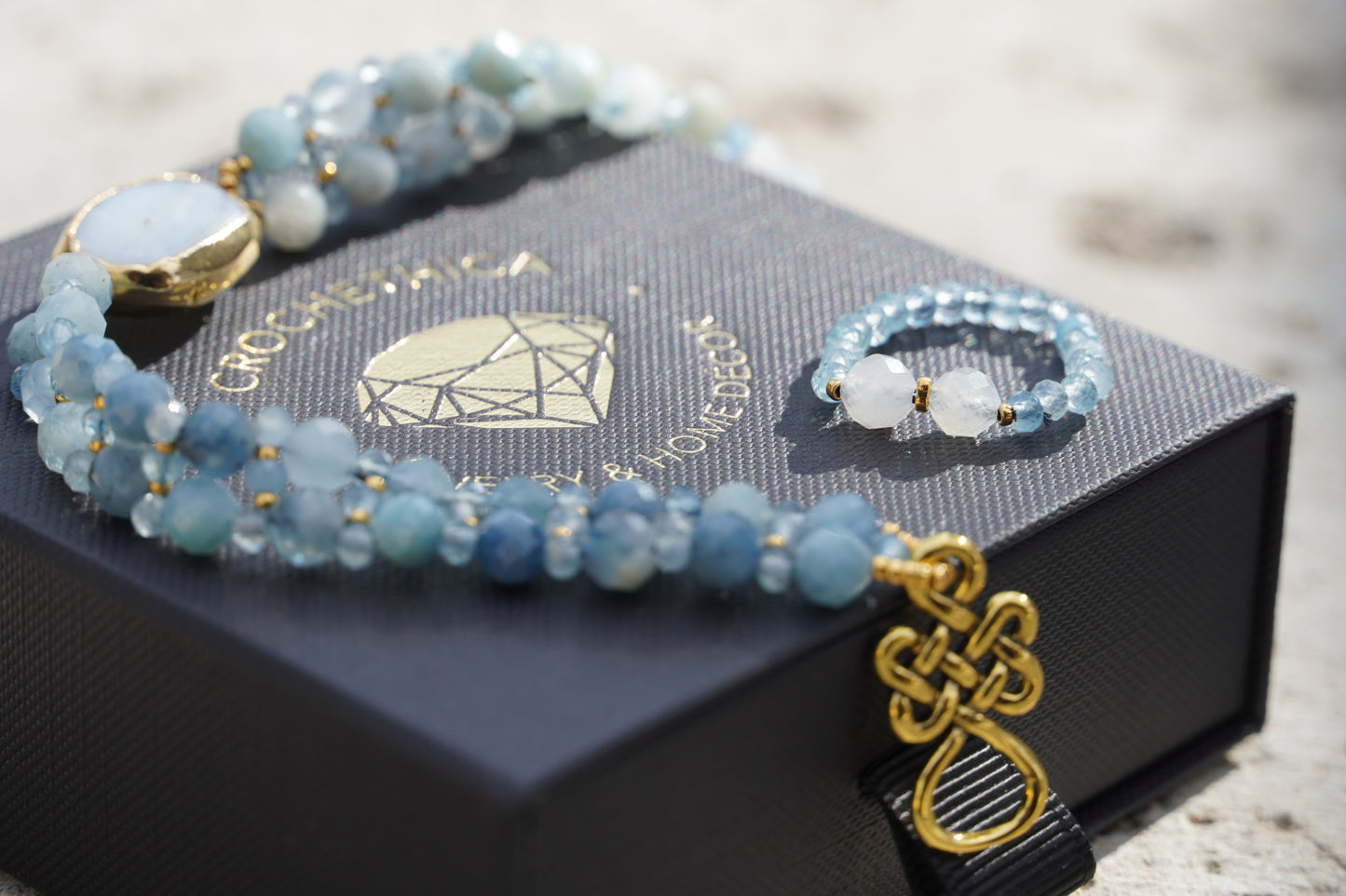 Close-up of aquamarine beads and gold Japanese bead accents on handmade ring and gemstone bracelet