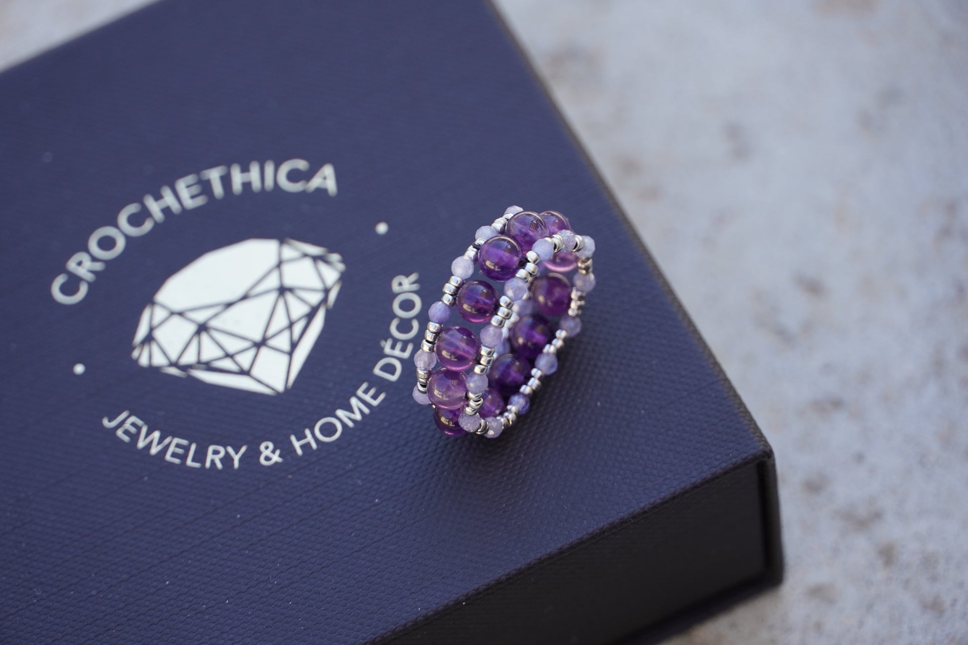 Purple beaded ring on a jewelry box