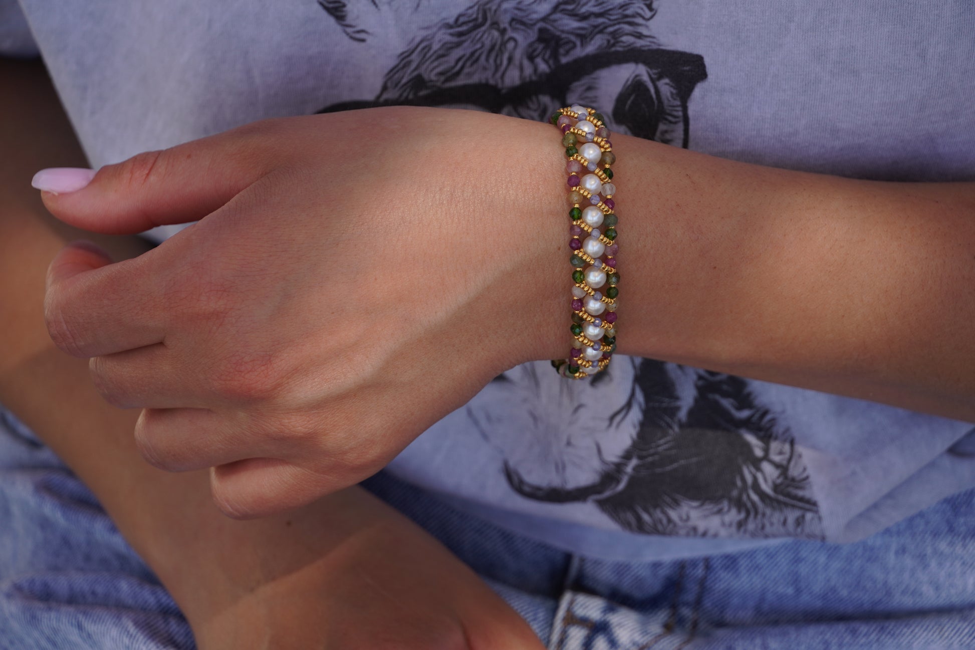 Close-up of a hand wearing a beaded bracelet with a blurred background