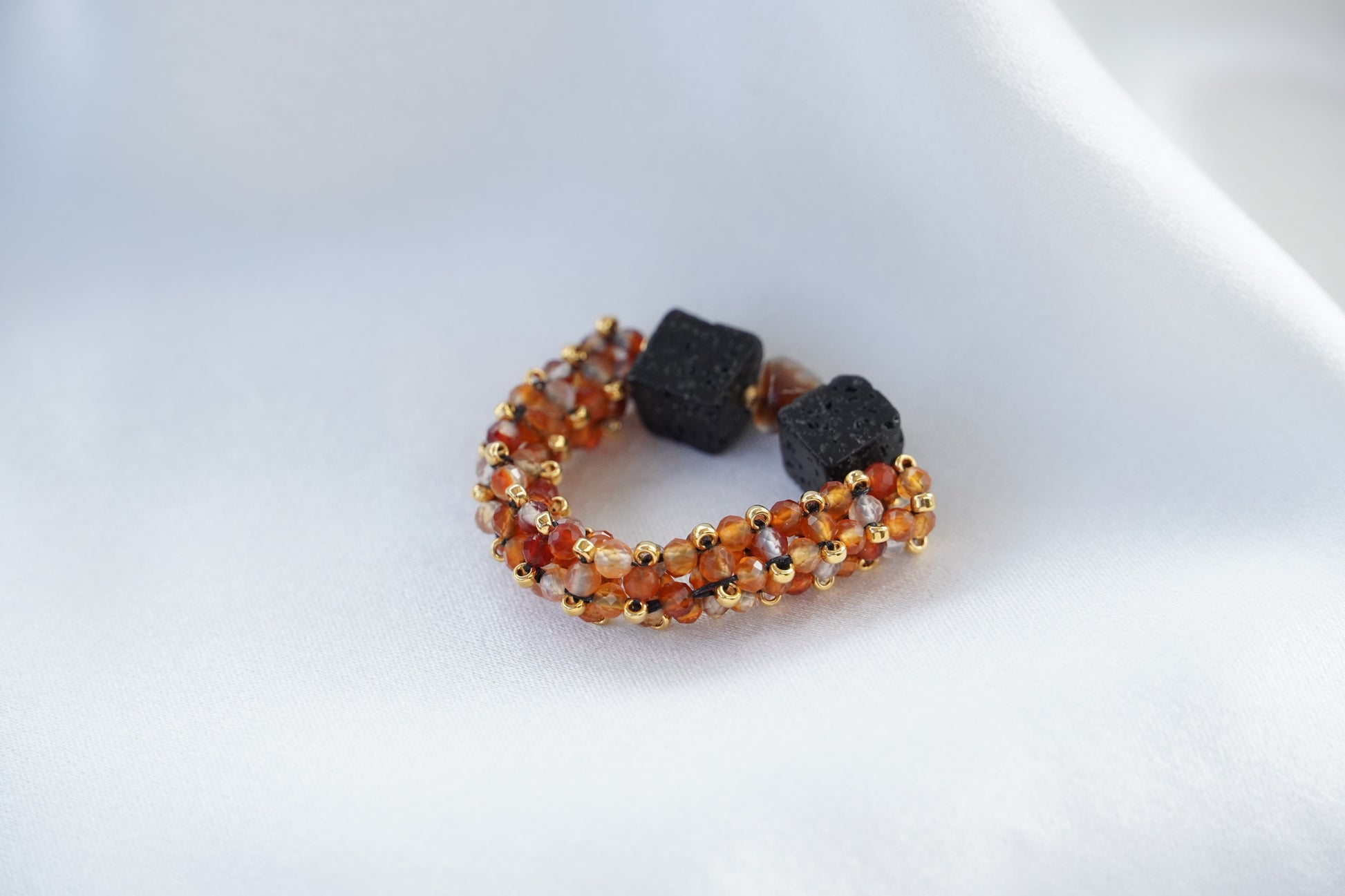 Closeup of a beaded carnelian ring with black lava