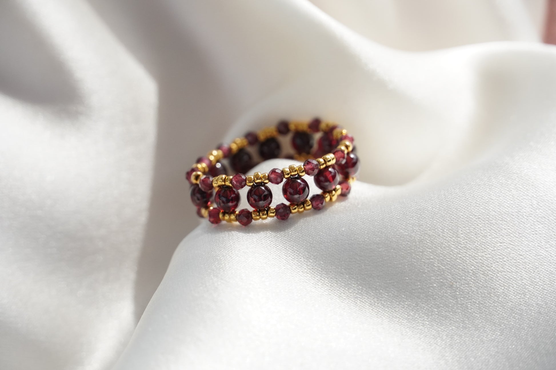 Multicolored beaded ring on a white fabric background