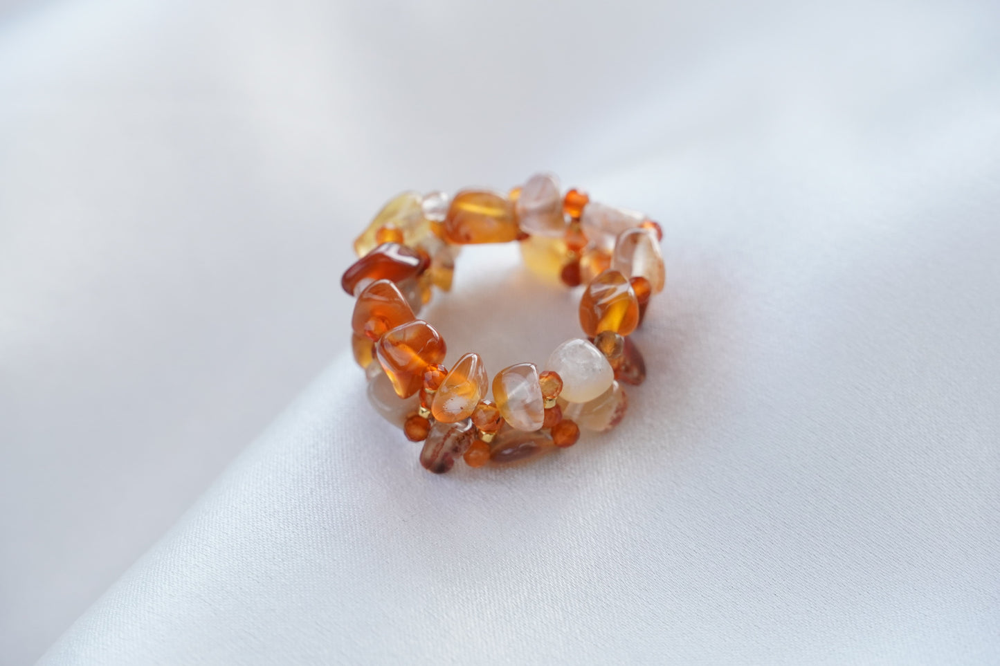 Amber-colored beaded ring on a white surface